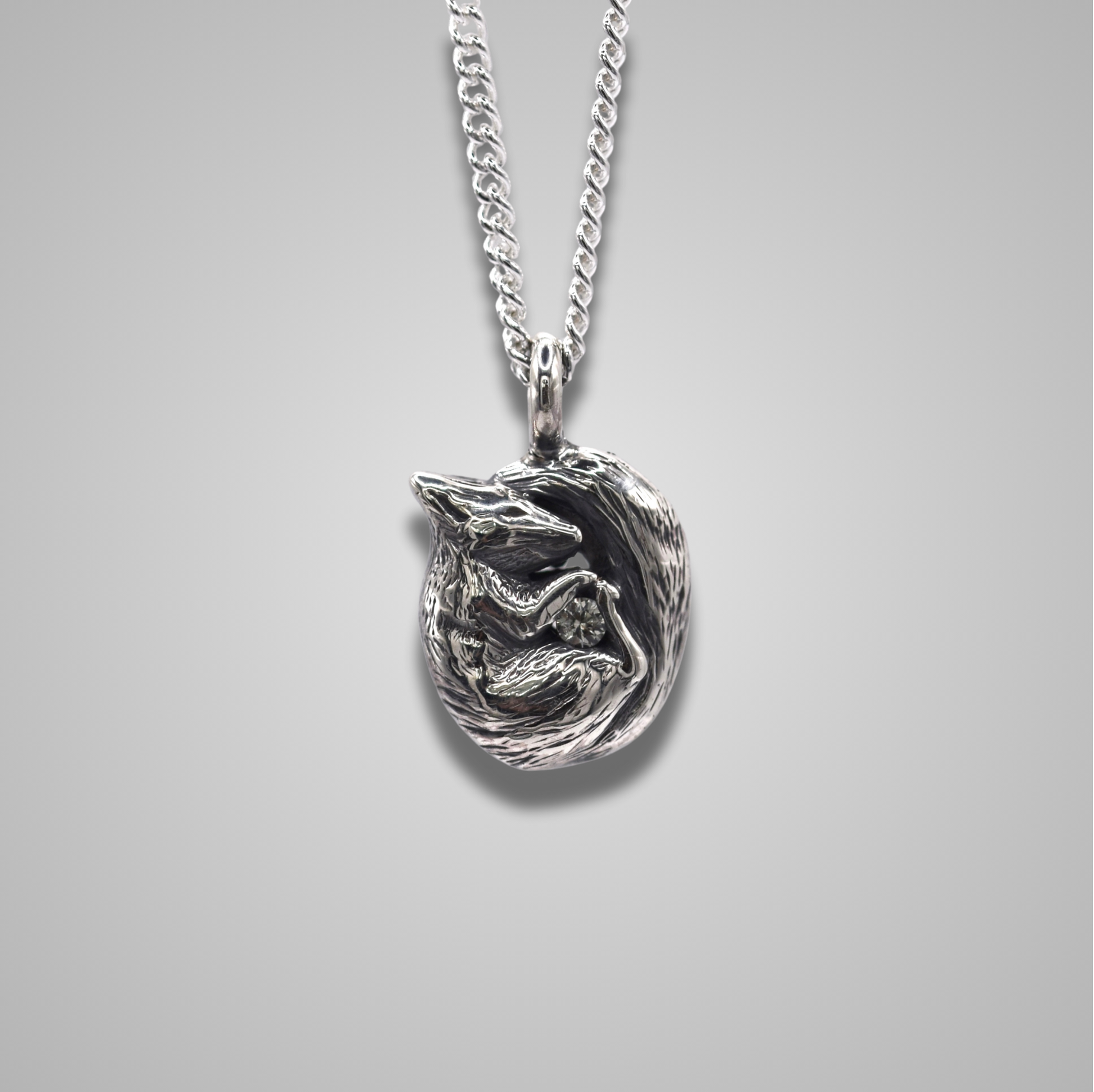 A curled up squirrel snuggling a gemstone. The squirrel is realistic and detailed. The sparkly stone is a white sapphire. 